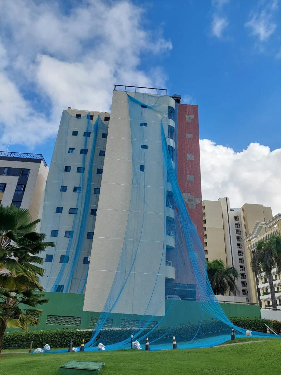 Edifício Montecarlo durante os serviços de recuperação da fachada, com tela de proteção instalada.